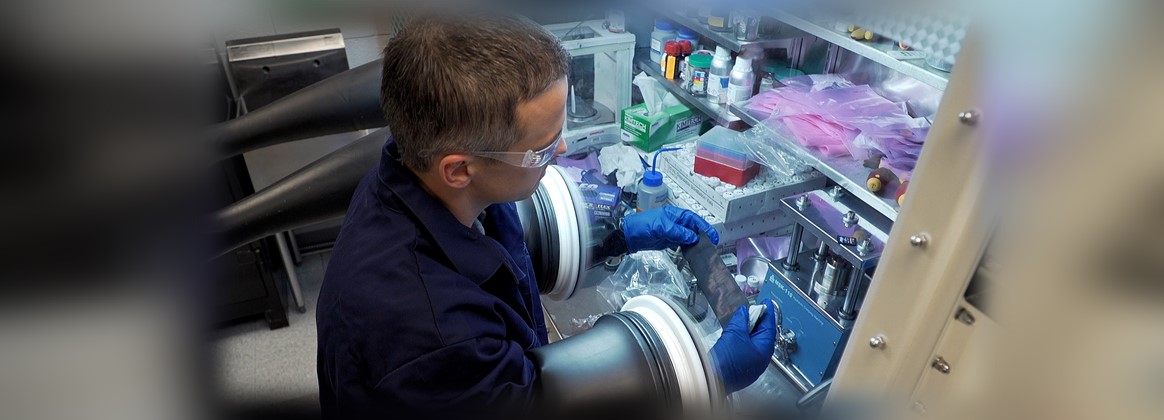  A man in safety glasses works in a laboratory. 